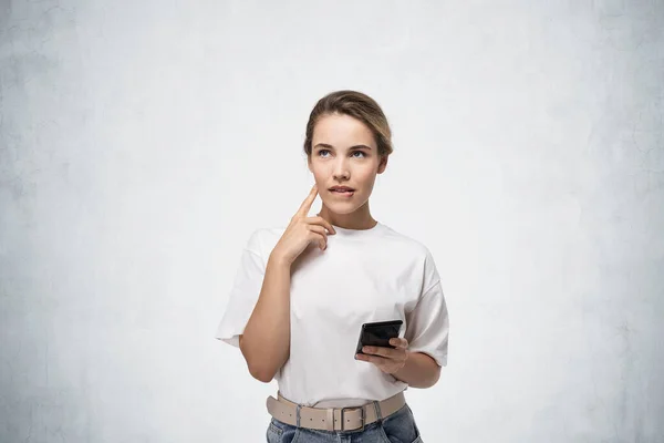 Retrato Joven Reflexiva Ropa Casual Sosteniendo Teléfono Inteligente Cerca Pared — Foto de Stock