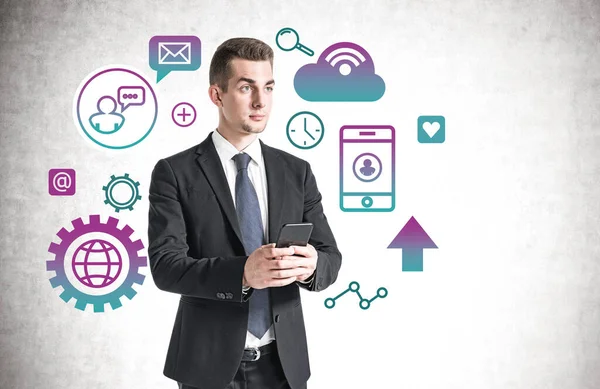 Serious Young Businessman Using Smartphone Concrete Wall Cloud Computing Icons — Stock Photo, Image