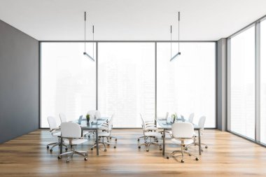 Gri ve ahşap ofis odası, beyaz sandalyeler ve dizüstü bilgisayarlı masalar, şehir manzaralı büyük pencerenin yanında. Modern minimalist ofis odası 3 boyutlu, insan yok.