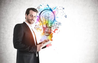 Üzerinde iş fikri çizimi olan beton duvarın yanında duran tabletle gülümseyen işadamı. Model