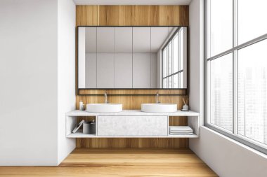 Tahta ve beyaz banyo, havluları olan iki lavabo, şehir manzaralı büyük pencerenin yanında büyük bir ayna. Minimalist tasarım modern fayanslı banyo ahşap zemin döşemeli, insan yok.