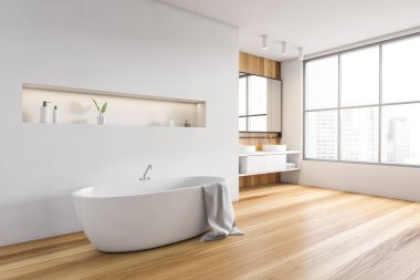Havlulu küvetli ahşap ve beyaz banyo, yan manzara, şehir manzaralı geniş pencere. Minimalist tasarım, ahşap zemini olan modern beyaz banyo, insan yok.