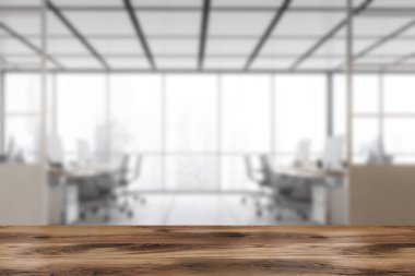 Ön planda ahşap masa, pencerenin yanındaki masalarda ve bilgisayarlarda bulanık beyaz ofis odası. Mermer zeminde modern mobilyaları olan beyaz ofis odası, 3 boyutlu, kimseyi göstermiyor.