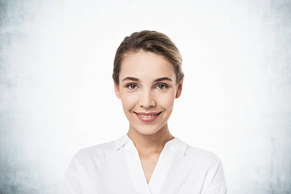 Portret Uśmiechniętej Młodej Europejskiej Biznesmenki Patrzącej Ciebie Przy Betonowym Murze — Zdjęcie stockowe