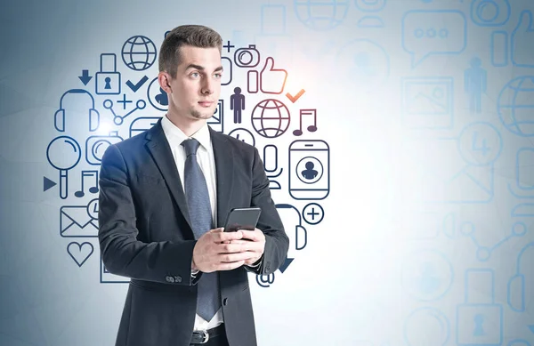 Retrato Joven Empresario Serio Parado Con Teléfono Inteligente Cerca Pared —  Fotos de Stock