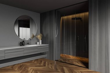 Gri ve ahşap duvarları olan şık banyonun köşesi, ahşap zemin, duş kabini ve yuvarlak ayna ile lavabo. 3d oluşturma