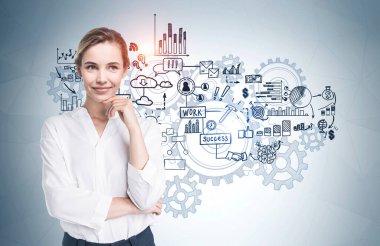 Üzerinde beyin fırtınası çizimi olan gri duvarın yanında duran neşeli genç iş kadını..