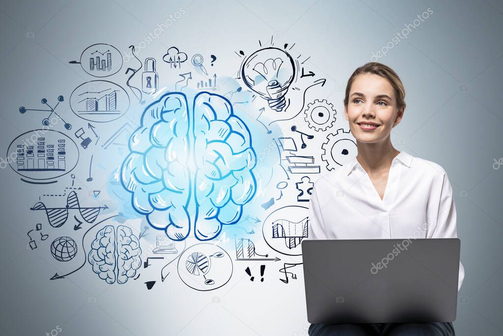 Smiling young woman with laptop sitting near gray wall with brain sketch drawn on it. Concept of brainstorming