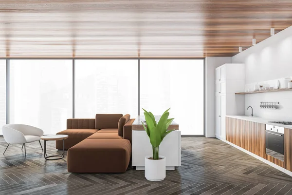 Living room with brown sofa and wooden coffee table with white armchair with plant, wooden parquet floor. Grey kitchen set with shelves, window with city view 3D rendering no people