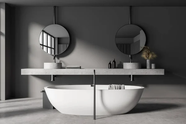 带有灰色墙壁 混凝土地面 舒适浴缸和双面水槽的时尚浴室室内有两个圆形镜子 3D渲染 — 图库照片