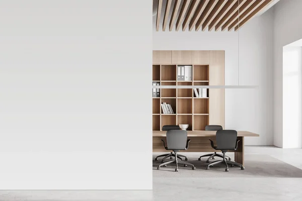 Interior of modern office meeting room with white and wooden walls, concrete floor and long conference table. Mock up wall to the left. 3d rendering