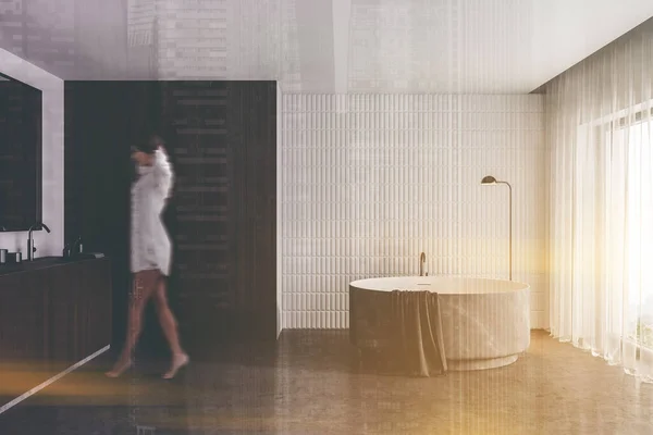 白とグレーの井戸 コンクリートの床 円形のバスタブとシンクと現代的なバスルームで歩く若い女性がブリュリー トーン画像二重露光 — ストック写真