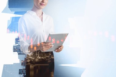 Bulanık bir gece şehrinde tabletle çalışan tanınmayan bir iş kadını. Borsa analizi kavramı. Tonu ayarlanmış resim