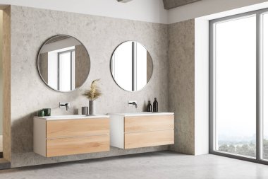 Beyaz ve ahşap duvarlı şık bir banyonun köşesi, beton zemin, yuvarlak aynalı çift lavabo ve bulanık manzaralı bir pencere. 3d oluşturma