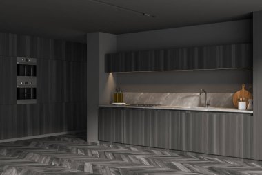 Gri duvarları, ahşap zeminleri ve dolapları olan şık bir mutfağın köşesi.