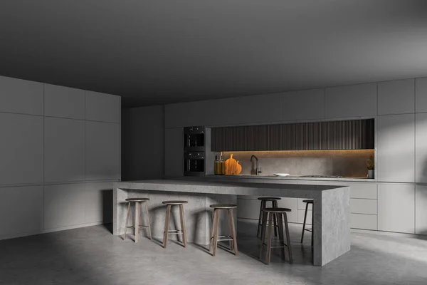 Corner of stylish kitchen with gray walls, concrete floor, bar counter and two ovens. 3d rendering