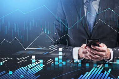 Tanımlanamayan iş adamının elleri bulanık mavi arka planda çift taraflı grafikle akıllı telefon kullanıyor. Tonu ayarlanmış resim