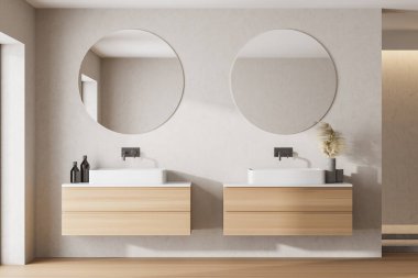 Gri duvarları, ahşap zemini ve iki yuvarlak aynalı iki lavabosu olan şık bir banyo. 3d oluşturma