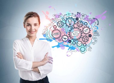 Üzerinde renkli beyin çizimi olan gri duvarın yanında duran kendine güvenen genç Avrupalı iş kadınının portresi.