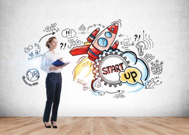 Beton duvara çizim çizimi yapılmış, planlayıcısı olan gülümseyen genç bir iş kadını. Başarı kavramı ve yeni iş projesi başlatılması