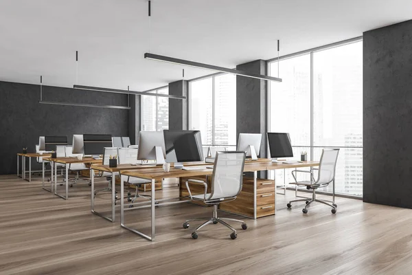 Wooden office room with armchairs and computers on the tables near windows, side view. Grey and wooden office room with modern minimalist furniture, 3D rendering no people