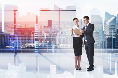 Yakışıklı ve arkadaş canlısı görünen Avrupalı iş adamı, zeki ve güzel meslektaşıyla modern bir ofiste iş meselelerini tartışıyor. Tonlanmış görüntü. Şehir manzarasının çifte pozlandırılması