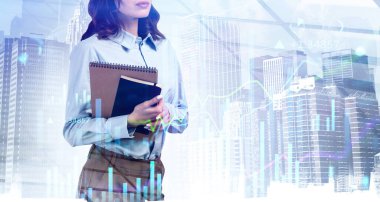 Elinde defterler ve planlar tutan bir finans analisti. Müşteri işlerini hızlandırmak ve istisnai mali sonuçlar elde etmek için yeni bir yaklaşım bulmaya çalışıyorum. Çifte maruziyet. Şehir manzarası ve finansal tablolar.