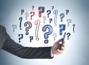 Akıllı telefonlu bir iş adamı mavi duvara karalama soru işaretlerinin mavi arkaplanını çizmiş. Faq ve seçenek kavramı.