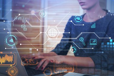 Çekici iş kadını iş yerinde oturuyor ve dizüstü bilgisayarda yazıyor. Arkasında ahşap duvarlar olan bir ofis. Ön planda dijital arayüz var. Elektronik aygıt ile ağ oluşturma kavramı