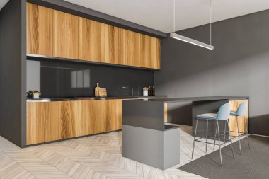 Gri mutfak seti, siyah masa ve iki mavi bar sandalyesi, aydınlık zemin. Minimalist mobilyalar, yan görüş, mutfak gereçleri ve rafları olan mutfak iç mimarisi.