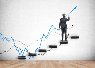Resmi takım elbiseli bir işadamı merdivende kalıp beton duvara mavi bir grafik çiziyor. Meşe ağacından parke döşeme. Başarılı finansal iş yatırımları kavramı