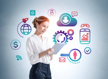 Ofisteki kadın elinde dijital tablet, mavi duvarda dijital ikonlar kullanıyor. Ofis ağı iletişim simgeleri, teknoloji, veri güvenliği ve kişisel bilgiler