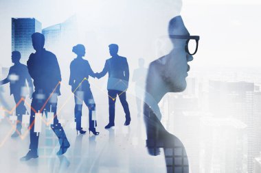 Sanal ofis alanında çalışan iş adamlarının silueti. Şehir merkezinde borsa çizgileri ve finansal tablolar, gökdelenlerle çift pozlama. Takım çalışması kavramı