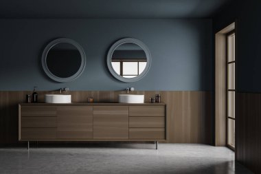 Dark stylish bathroom interior with two sinks and wooden drawer with bottles of gel, two round mirrors. Window and concrete floor, 3D rendering no people clipart