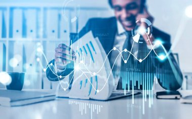 Afrika kökenli Amerikalı iş adamı telefonla konuşuyor ve iş belgeleriyle çalışıyor. Grafik değişiklikleri, ön x finansal dinamikleri. Çizgilerin, pasta grafiğinin ve sayıların iki katına çıkması. Analiz kavramı