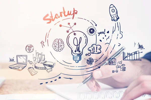 Businessman with pen, writing in notebook. Drawing of multiple doodle symbols, light bulb with graphs and financial analysis. Concept of start up and business ideas