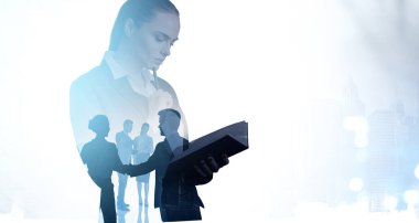 Ofisteki kadın ellerinde defter okuyor, birlikte çalışan insanların siluetlerini iki kez gösteriyor. Uluslararası şirkette ve sekreterde ağ kavramı