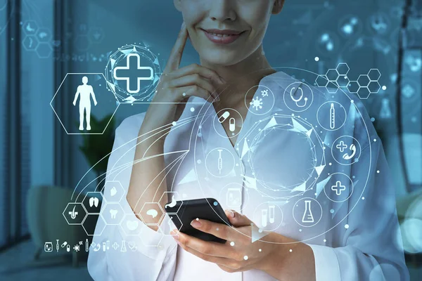 病院でスマートフォンに取り組む魅力的な女性医師 人間の健康の神経治療 手術や医学研究 体の部分を含む前景にガラスの画面上に描かれたメッドアイコン — ストック写真
