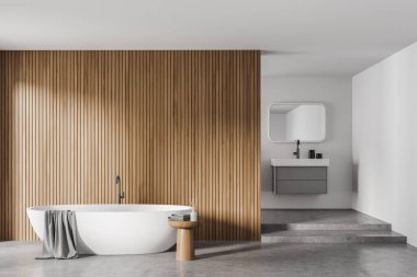 Beton zeminde beyaz küvet ve banyo aksesuarlarıyla aydınlık banyo, bölmenin arkasında ayna ile lavabo. Modern mobilyaları olan minimalist bir oda, ön manzara, 3 boyutlu, kimseyi yansıtmayan.