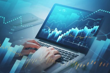 Hisse senedi almak veya satmak için dizüstü bilgisayar kullanarak hisse senedi grafiği ve finansal göstergeleri analiz eden işadamı veya borsa simsarı