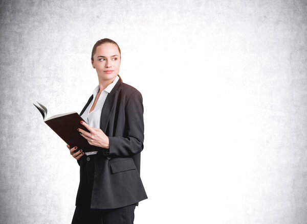 Офисная женщина в черном костюме держит в руках бумажный отчет. Профессиональный менеджер читает бизнес-заметки. Образец пустой стены для копирования, концепция бизнес-работника