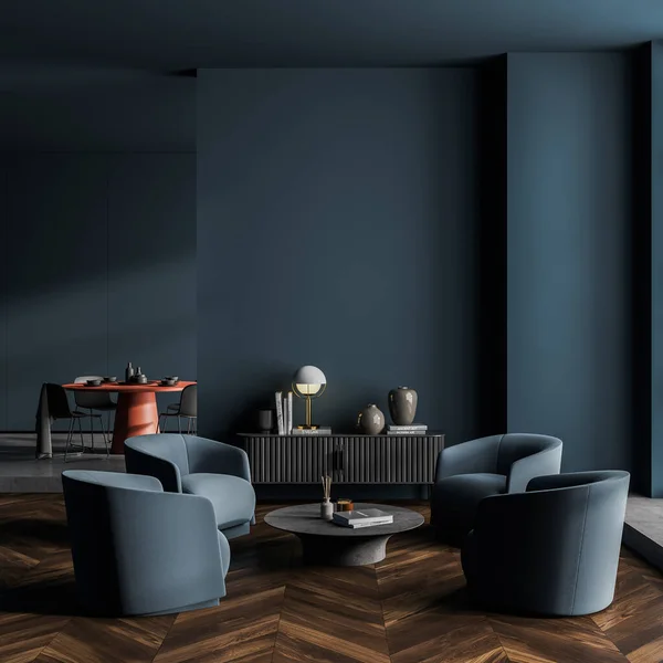 Luxury blue living room, hotel suite, office lounge interior with four dark blue armchairs standing near a round table. Cabinet with poster and lamp and dining room in the background. 3d rendering