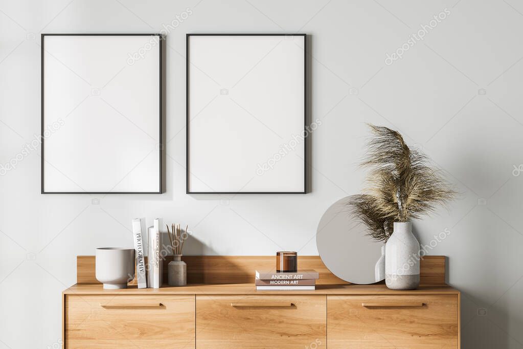 White exhibition art room interior with wooden drawer, books and mirror with vase. Two blank posters in a row, canvas on wall, 3D rendering