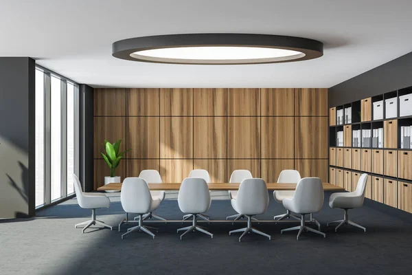 Interior of futuristic and classic hotel business center meeting room with gray and wooden walls, long conference table with white chairs and bookcase with binders and folders. 3d rendering