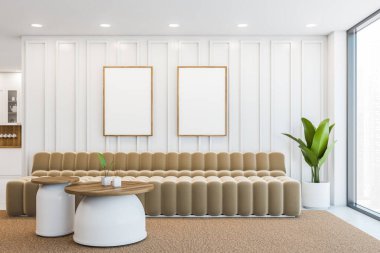 Modern ofis bekleme odasının içinde beyaz duvarlar, arka planda iki yuvarlak sehpası ve küçük ofis mutfağı olan bej bir kanepe. İki dikey poster çerçevesi. 3d oluşturma