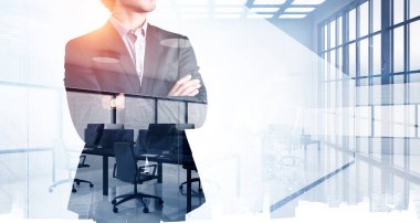 Ofisteki adam ayakta duruyor, iş kıyafetleri içinde özgüven profili, mobilya ve teknolojiyle konferans salonunun tonlu görüntüsü. İş liderliği ve yenilik kavramı