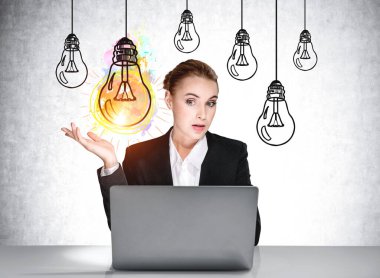 Resmi olarak çok çekici bir iş kadınının portresi dizüstü bilgisayarın önünde oturuyor, arkadaki beton duvara çeşitli ampuller çiziyor. İş kurmak için yeni bir fikir