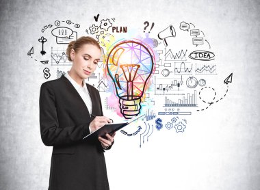 Çekici iş kadını not defterine notlar alıyor ve renkli iş fikri ampulü çizimi ve iş akışı çizelgesiyle beton duvarın yanında kafa yoruyor. Yaratıcılık ve beyin fırtınası kavramı