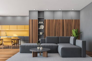 Stüdyo mutfağı ve oturma odası ile iç mekan. Gri duvarlar, halı ve sehpalı köşe kanepe. Ahşap masa, bulaşık ve zemin için çanta. Sarı dolaplar ve koltuklar. 3d oluşturma