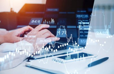 Dizüstü bilgisayarla çalışan tüccar elleri. Borsa değişiklikleri, iş şamdanları grafiği. Hologram dijital veri. İnternet ticareti kavramı